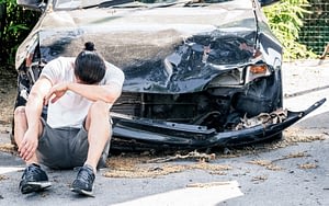 Man with wrecked car following a crash